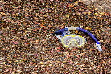 life style snorkeling mask and tube on stone beach near sea