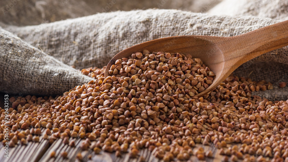 Wall mural rural still-life - the peeled groats of buckwheat (fagopyrum esculentum) on the background of burlap