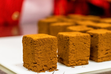 Cocoa coated mousse brownies on the white background.