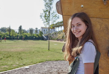 Young and smiling girl looking at camera in the park