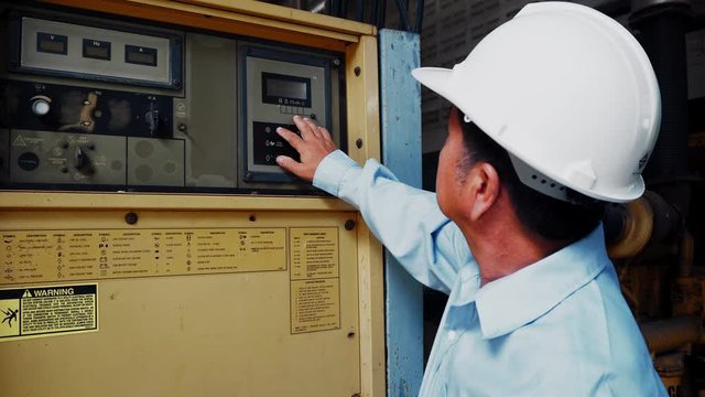 An asian senior engineer or mechanic using industrial power generator in factory 