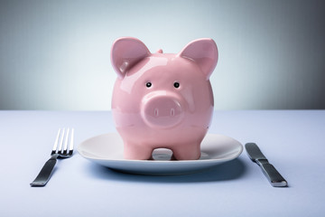 Piggy Bank On The Plate With Fork And Knife