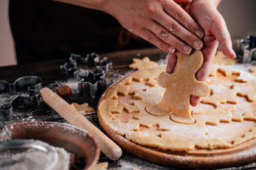 Christmas and New Year celebration traditions. Traditional festive food making, family culinary. Friends cutting cookies of raw gingerbread dough