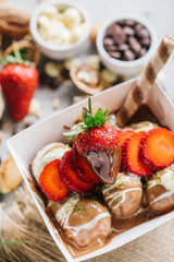 turkish lokma turkish bite dessert with chocolate and white chocolate sauce. strawberry and banana new generation bite