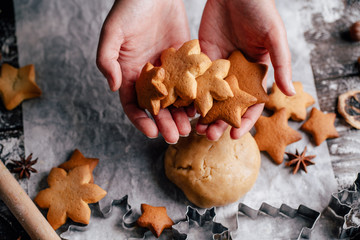 Christmas bakery. Freshly baked homemade gingerbread cookies, dough cutters, rolling pin and food decorations on the table.Family festive culinary and New Year traditions concept