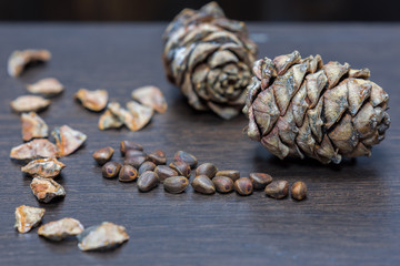 Pine nuts on a wooden table next to the cones