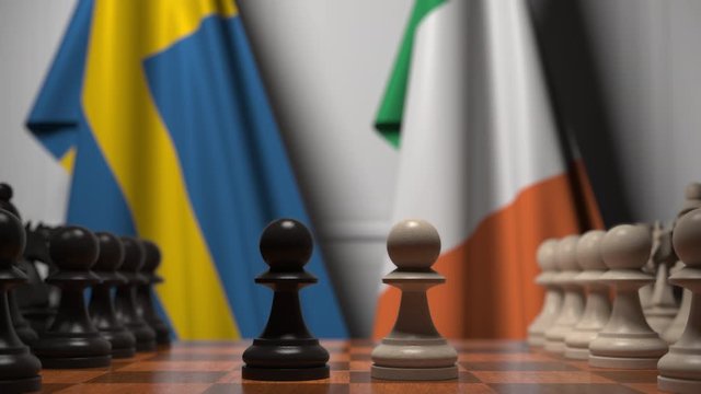 Flags of Sweden and Ireland behind pawns on the chessboard. Chess game or political rivalry related 3D animation