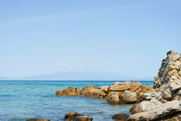 Fototapeta na wymiar Sea horizon and rocks by the seaside in sunny day water or ocean