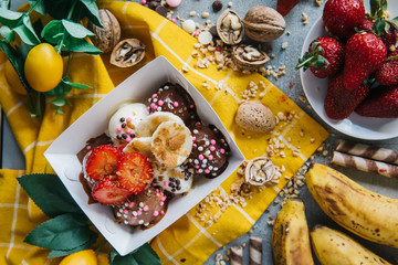 turkish lokma turkish bite dessert with chocolate and white chocolate sauce. strawberry and banana new generation bite