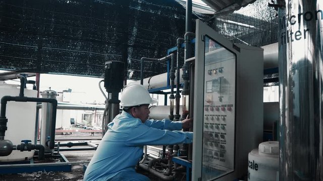 An asian senior engineer or mechanic using water power generator in factory 