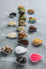 Food in spoons. Variety of  chocolate, hazelnut, peanut, pistachio, bonbon, wafer rolls, white chocolates, dark chocolates, milky chocolates, bite dessert, granulated sugar, crunch, coconut powder