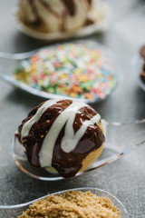  Food in spoons.Bite on a spoon. turkish bite dessert with chocolate and white chocolate sauce.