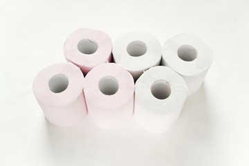 白バックの中央に3ロールずつ2列に置いてある白とピンクの新品のトイレットペーパー