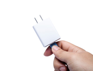 The hand of a man holding an adapter for a phone charger