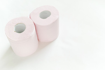 白バックの左寄りに置いてある二つのピンクの新品のトイレットペーパー