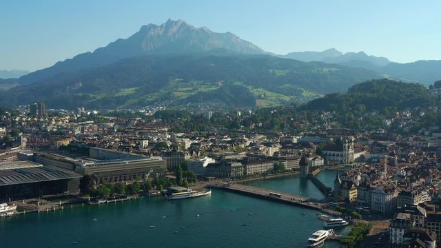 sunny evening flight over luzern cityscape train station lakeside bridge bay aerial panorama 4k switzerland