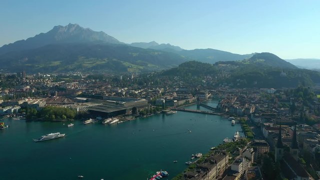 sunny evening flight over luzern cityscape train station lakeside bridge bay aerial panorama 4k switzerland