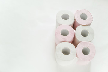 白バックの右寄りに3ロールずつ２列に置いてある白とピンクの新品のトイレットペーパー