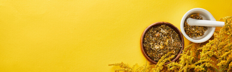 panoramic shot of mortars with pestle on yellow background with goldenrod