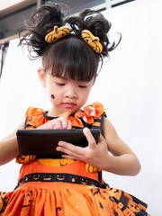 Asian children girl in pumpkin dress costume for Halloween decoration in white background