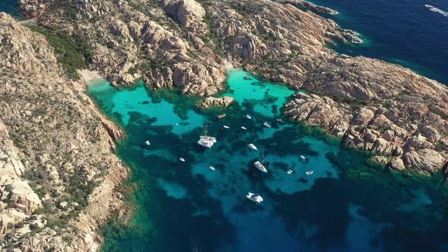 View from above, stunning aerial view of Cala Coticcio also known as Tahiti with boats and yachts floating on a turquoise clear water. La Maddalena Archipelago, Sardinia, Italy.