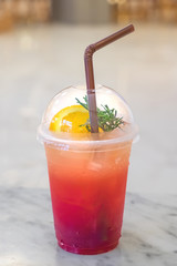Glass of ice tea juice mixed soda and lemon. beautiful red and orange juice color.