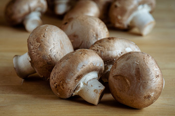 Close up of white mushrooms on a wooden table tap.