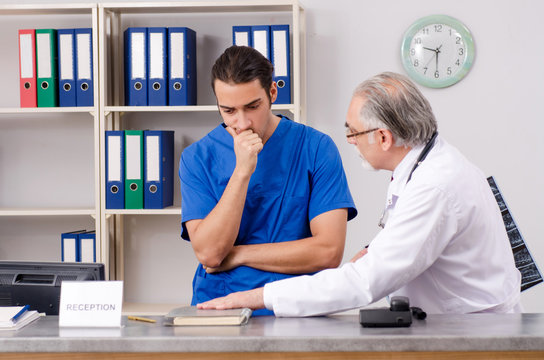 Two Doctors Talking At The Reception In Hospital