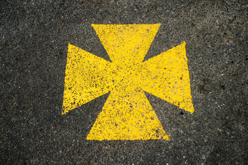 Fototapeta premium Yellow maltese cross, ambulance parking lot marked with yellow symbol.