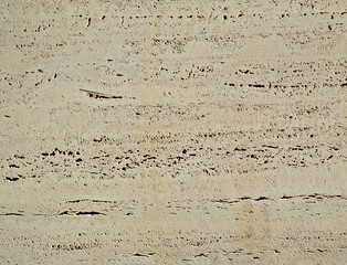 Marble surface with visible mineral inclusions and texture left by the cutting tool.