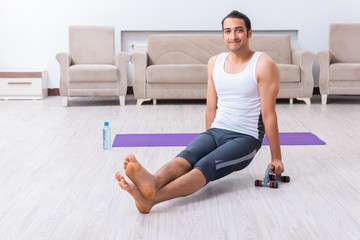 Fototapeta premium Young man training and exercising at home