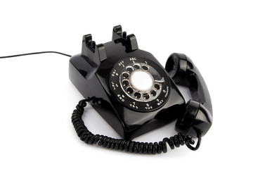 vintage  black rotary telephone with receiver off the hook isolated on a white background