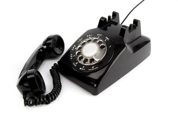 vintage  black rotary telephone with receiver off the hook isolated on a white background