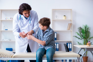 Fototapeta premium Hand injured boy visiting young male doctor