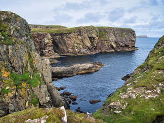 Sandstone cliffs on the East Shetland coast near Levenwick showing eroded rock strata - the bedrock...