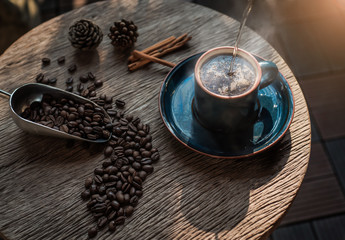 cup of coffee with beans on wooden table