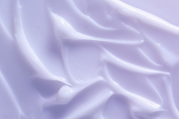 Cosmetic lotion background. Light purple cream smeared. Moisturizer, mask, creamy skin care product...