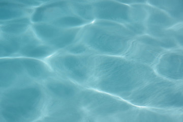 Close up full frame view of the reflecting water surface of a sunlit swimming pool