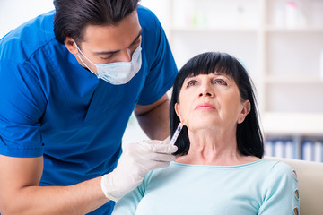 Fototapeta premium Old woman visiting male doctor for plastic surgery