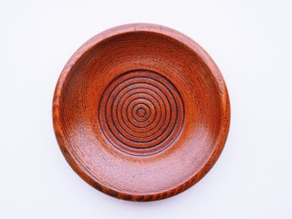 Round brown wooden plate with green leaves isolated on white table background. Health and eating Natural clean food concept.