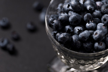 Crystal dessert cup full of blueberries on dark background