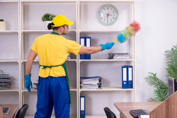 Young male contractor cleaning the office