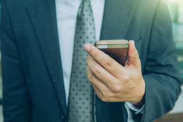Business man holding smart phone.