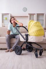 Young man looking after baby in pram