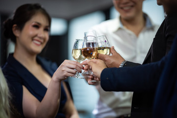 A group of business people holding a glass of champagne in a party to celebrate their success