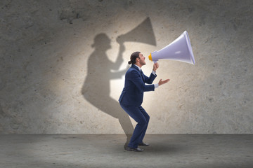 Businessman shouting through large loudspeaker