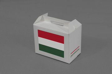 Hungarian flag on white box with barcode and the color of nation flag on grey background. The concept of export trading from Hungary.