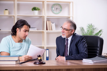Young man visiting experienced male lawyer