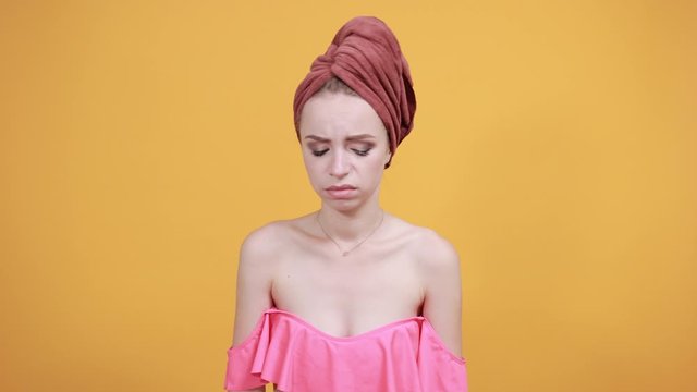 young girl with towel on her head over isolated orange background shows emotions