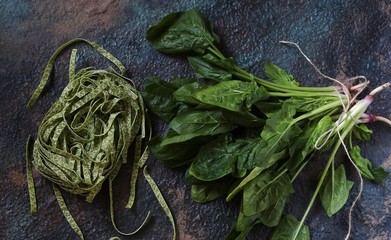 uncooked fettuccine pasta with spinach leaves. vegetarian cuisine.